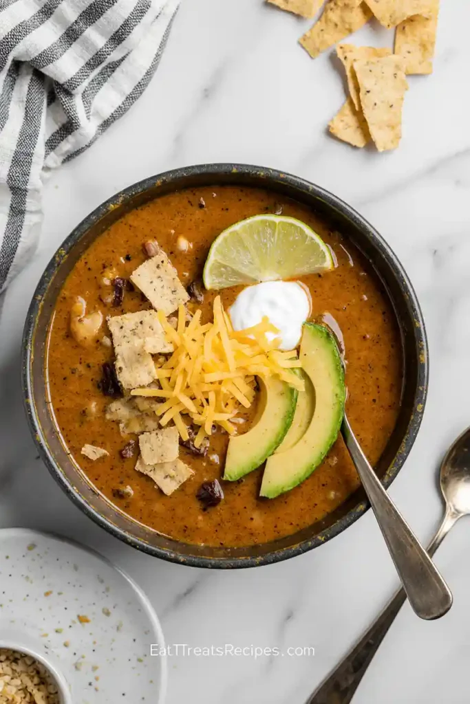 Bowl of creamy taco soup with toppings and lime