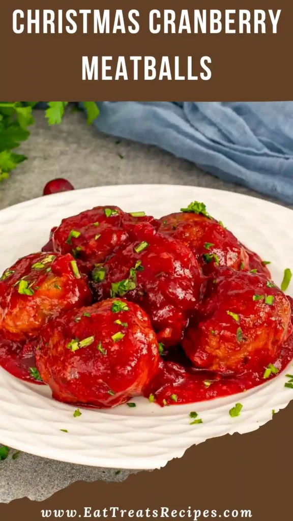 Christmas cranberry meatballs in glossy red sauce served on white marble