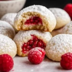 Christmas Raspberry Almond Snowball Cookies with raspberry filling and powdered sugar
