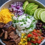Steak burrito bowl meal prep containers with rice and steak on white marble background
