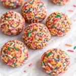 Birthday Cake Batter Protein Balls with colorful sprinkles on white marble background