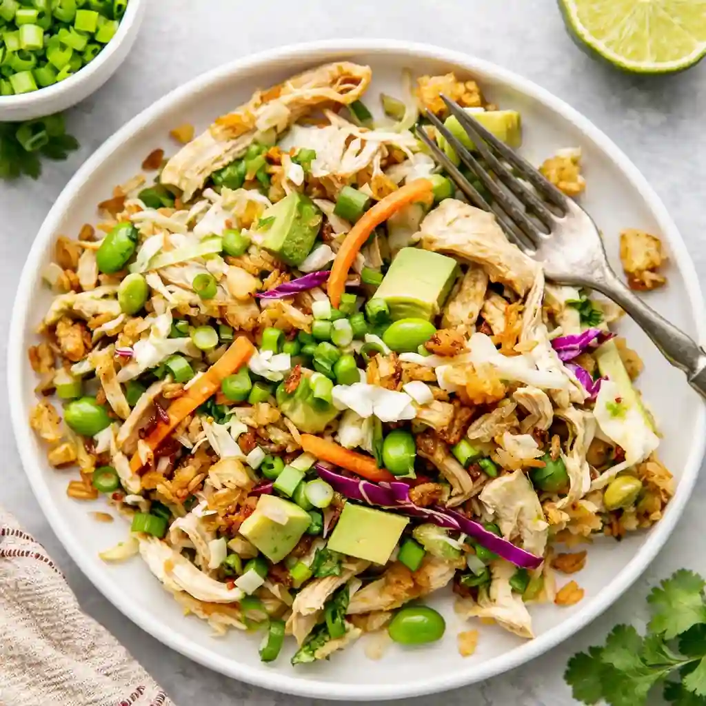 Chicken crispy rice salad in white bowl with golden crispy rice