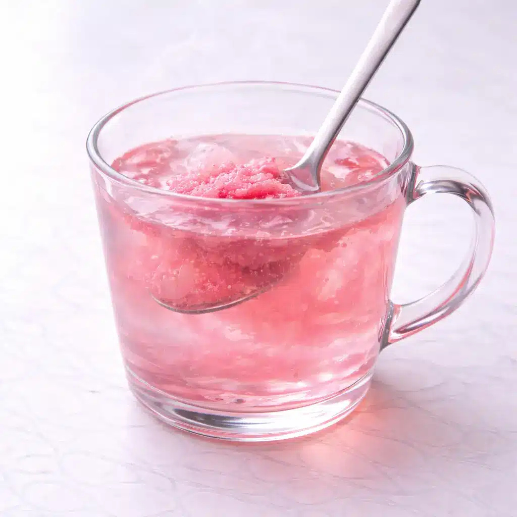 Gelatin Drink Recipe in clear glass mug on white marble surface, simple 3 ingredient gelatin trick drink
