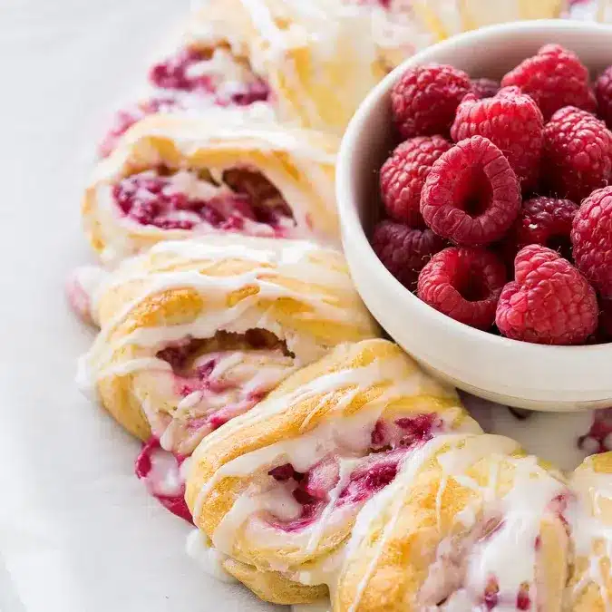 Lemon raspberry cream cheese danish rolls on white plate