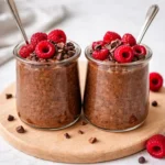 chocolate chia overnight oats in a jar topped with berries and cocoa