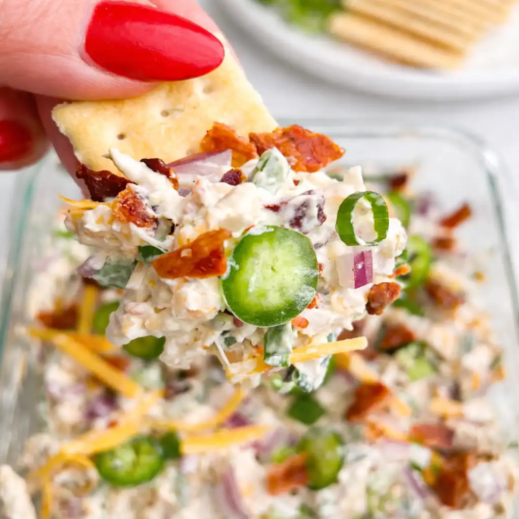 Creamy Jalapeno Popper Chicken Salad with bacon, cheddar and jalapenos served in white bowl on marble background