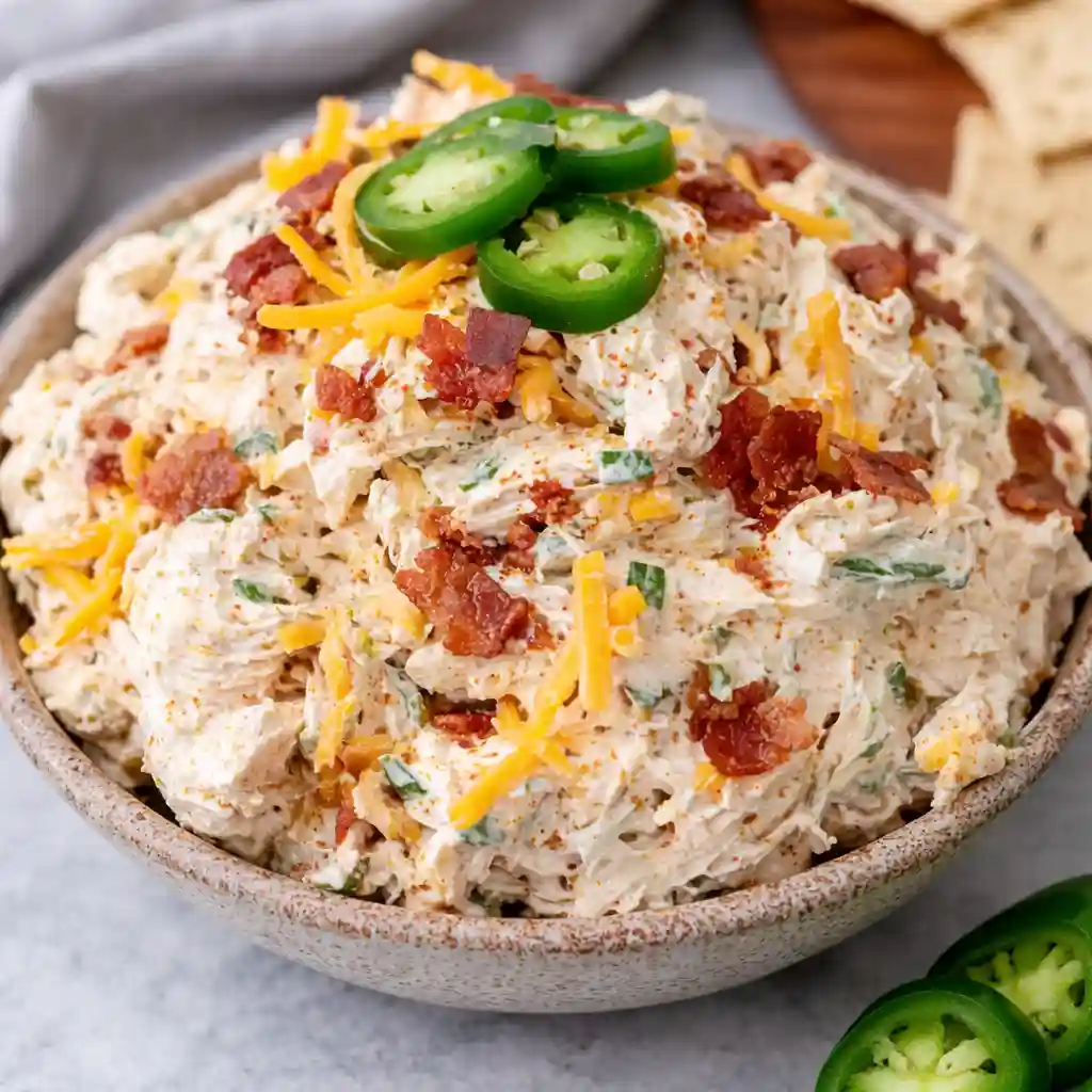 Creamy Jalapeno Popper Chicken Salad with bacon, cheddar and jalapenos served in white bowl on marble background