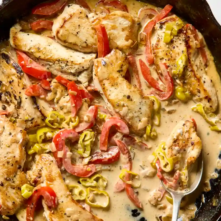 Creamy pepperoncini chicken served in white bowl with parsley garnish