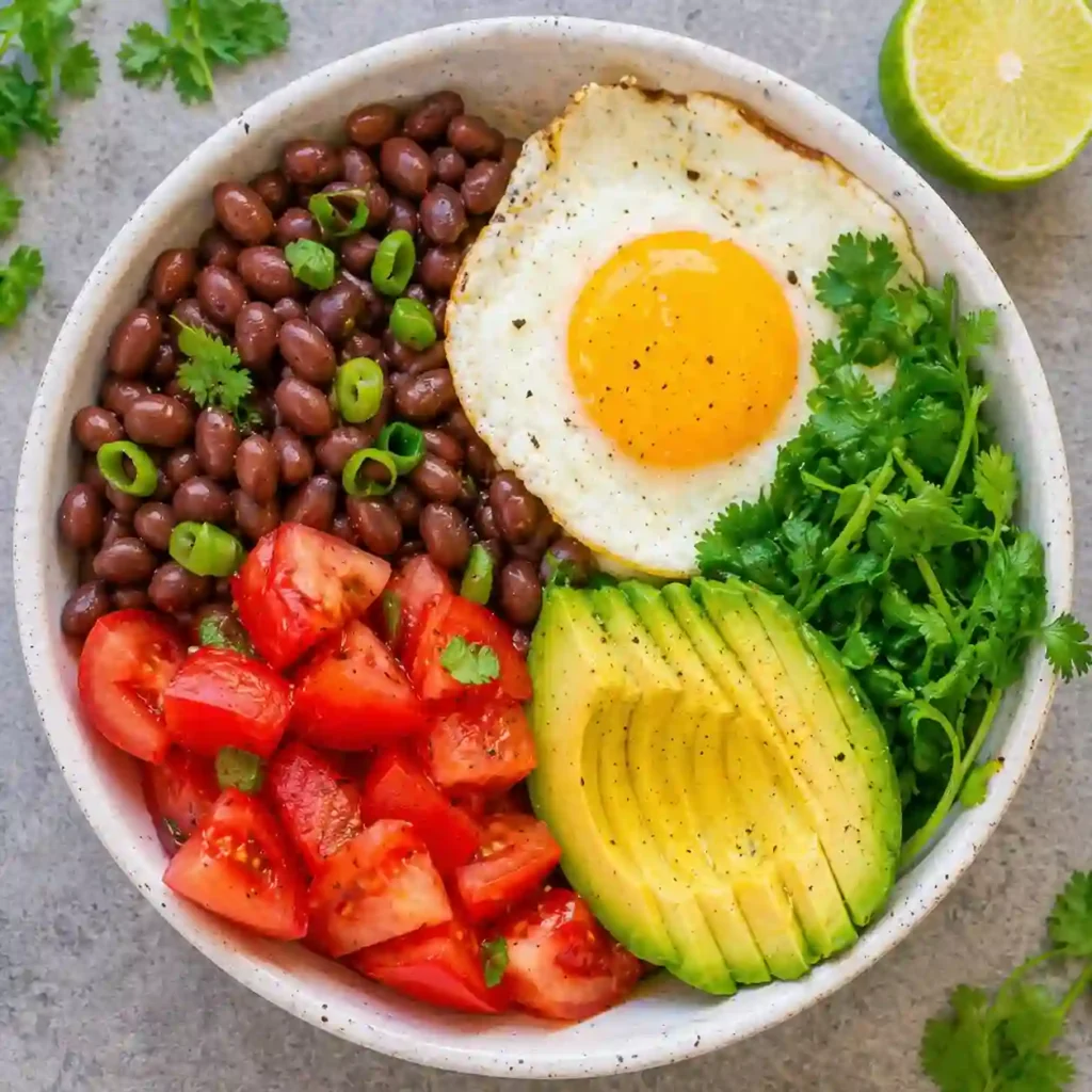healthy mexican breakfast bowl with eggs avocado beans