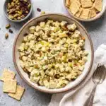 Minimalist presentation of simple classic chicken salad in a white ceramic bowl over a smooth white backdrop.